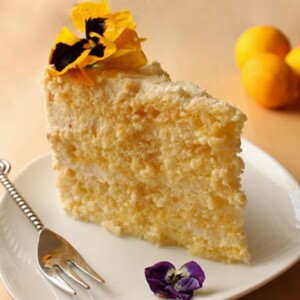 Slice of Lemon-Mascarpone Layer Cake on a white plate.