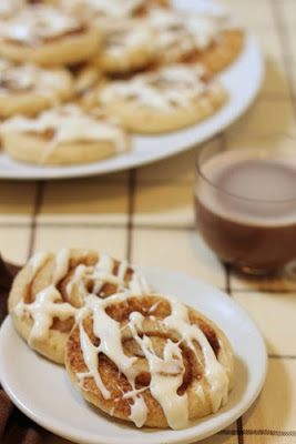 Cinnamon Roll Sugar Cookie near a cup of hot chocolate.