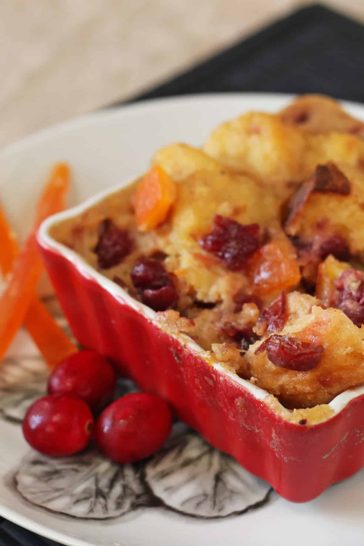 Cropped photo of Cranberry Orange Bread Pudding in a red ramekin. 