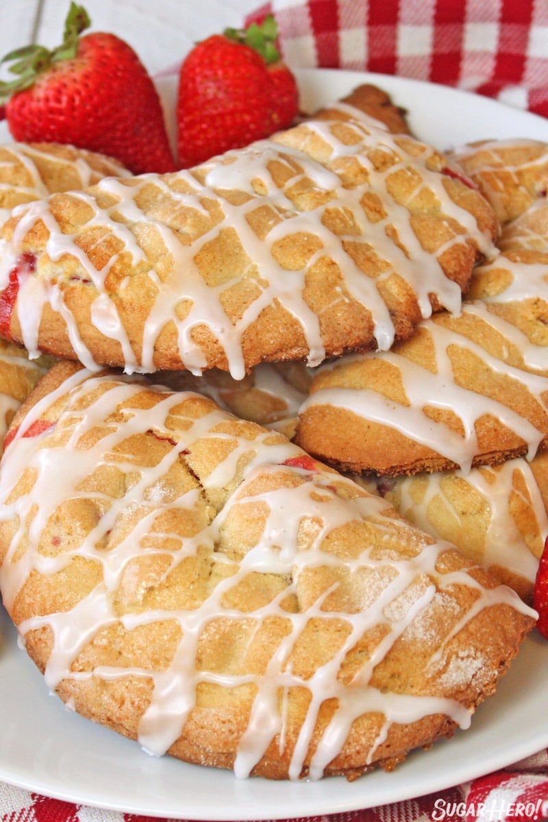 strawberry hand pies with white glaze on a white plate