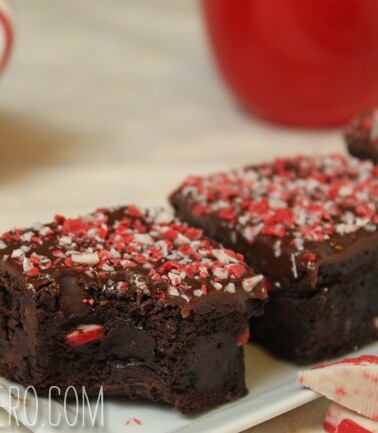 3 Peppermint Crunch Brownies on a white rectangular plate with a bite taken out of first brownie.