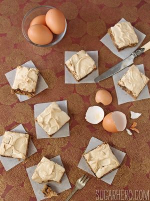 8 Meringue-Topped Blondies on a brown surface next to eggs.