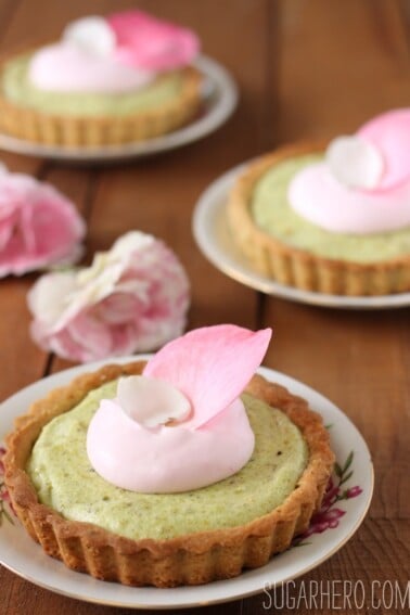 Pistachio-Rose Tarts with rose petals on top.