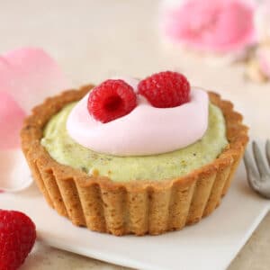 A Pistachio-Rose Tart on a white square dessert plate.