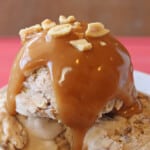 Close up of Peanut Butter Sauce drizzled over ice cream and topped with chopped peanuts.