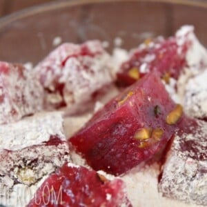 Raspberry-Pistachio Turkish Delight in a bowl of powdered sugar.