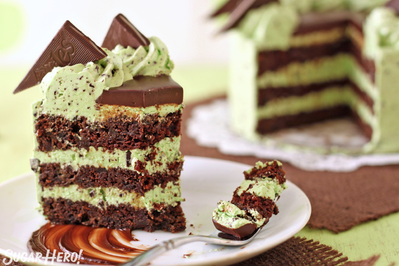 Slice of mint chocolate chip cake with several bites taken out of it, with a fork full of cake next to it on the plate