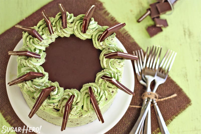 Overhead view of mint chocolate chip layer cake, with Andes mints ringing the outside and chocolate ganache in the center