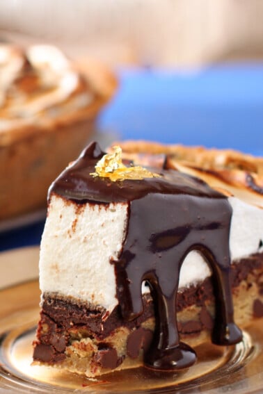 A slice of Moon Pie Pie on a clear plate with chocolate fudge sauce dripping off.
