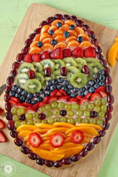 Overhead shot of Easter Egg Fruit Pizza on a wooden cutting board.