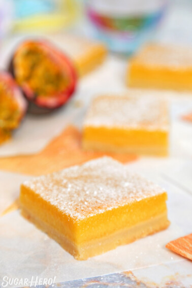 Passion Fruit Bars on a counter with passion fruit in the background.