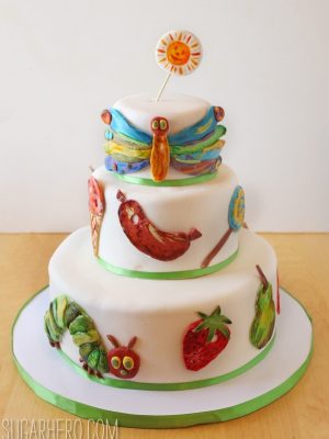 Close up of the Very Hungry Caterpillar Cake on a table with fondant designs.