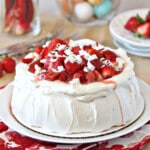 Close up of a Strawberry Rhubarb Pavlova piled with fresh fruit and white chocolate shavings.