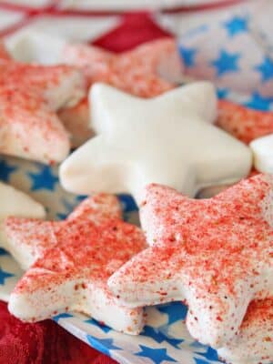 Star-shaped cookies dipped in white chocolate, some dusted with freeze-dried strawberry powder.