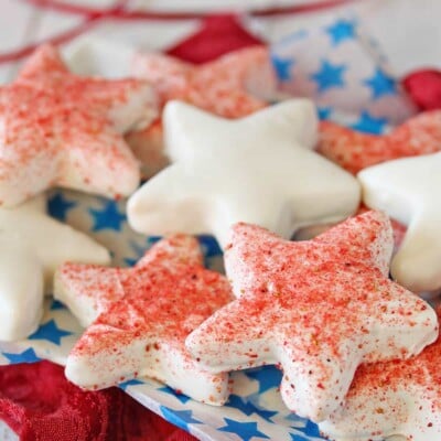 Star-shaped cookies dipped in white chocolate, some dusted with freeze-dried strawberry powder.