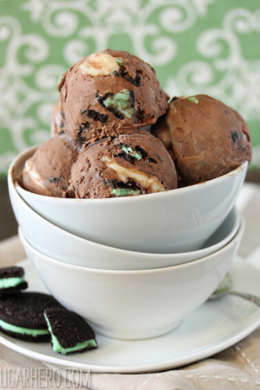 Several scoops of Chocolate Mint Swirl Ice Cream in a white bowl with Mint Oreos at the bottom.