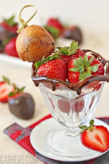 Strawberries in a small ice cream cup with a Deep Fried Chocolate-Covered Strawberry.