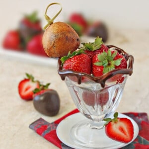 Strawberries in a small ice cream cup with a Deep Fried Chocolate-Covered Strawberry.