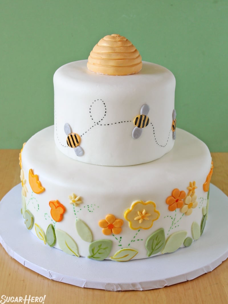 Bumblebee Cake - Shot of the layered cake with flowers and bees made of fondant. | From SugarHero.com 
