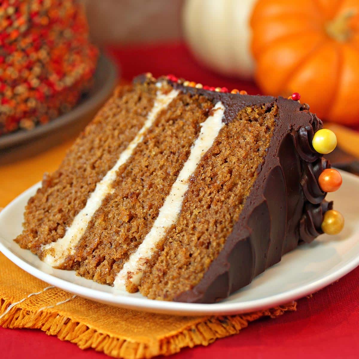 Close up of a slice of Pumpkin Layer Cake on a white plate.