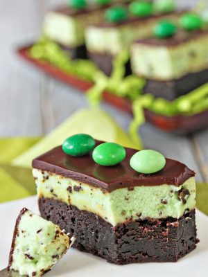 A Mint Chocolate Chip Mousse Brownies on a white plate with a fork holding a bite.