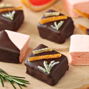 Grapefruit Marshmallows on a wooden surface next to rosemary.