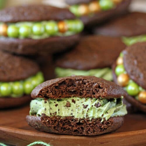 Close up of Mint Chocolate Chip Whoopie Pies on a wooden surface.