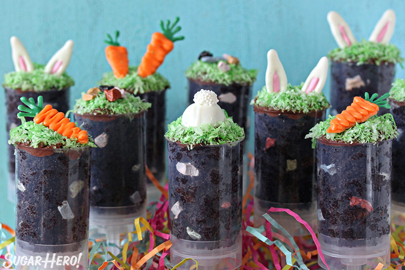 Nine Easter push-up pops filled with chocolate cake and topped with bunny ears, chocolate rocks or a chocolate carrot.