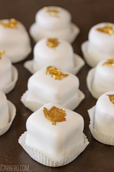 Basic Petit Fours lined up in rows on a wooden surface.