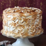 Close up of a Banana Meringue Cake on a white cake platter.