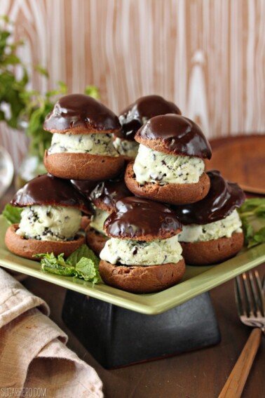 A pile of Chocolate Profiteroles with Fresh Mint Chip Ice Cream on a square green plate.