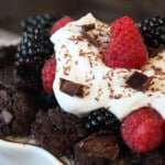 Close up of the whipped cream, fresh fruit and chocolate shavings on top of Brownie Bread Pudding.