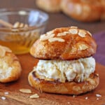 Close up of a Croissant Salted Honey Ice Cream Sandwich on a wooden surface.