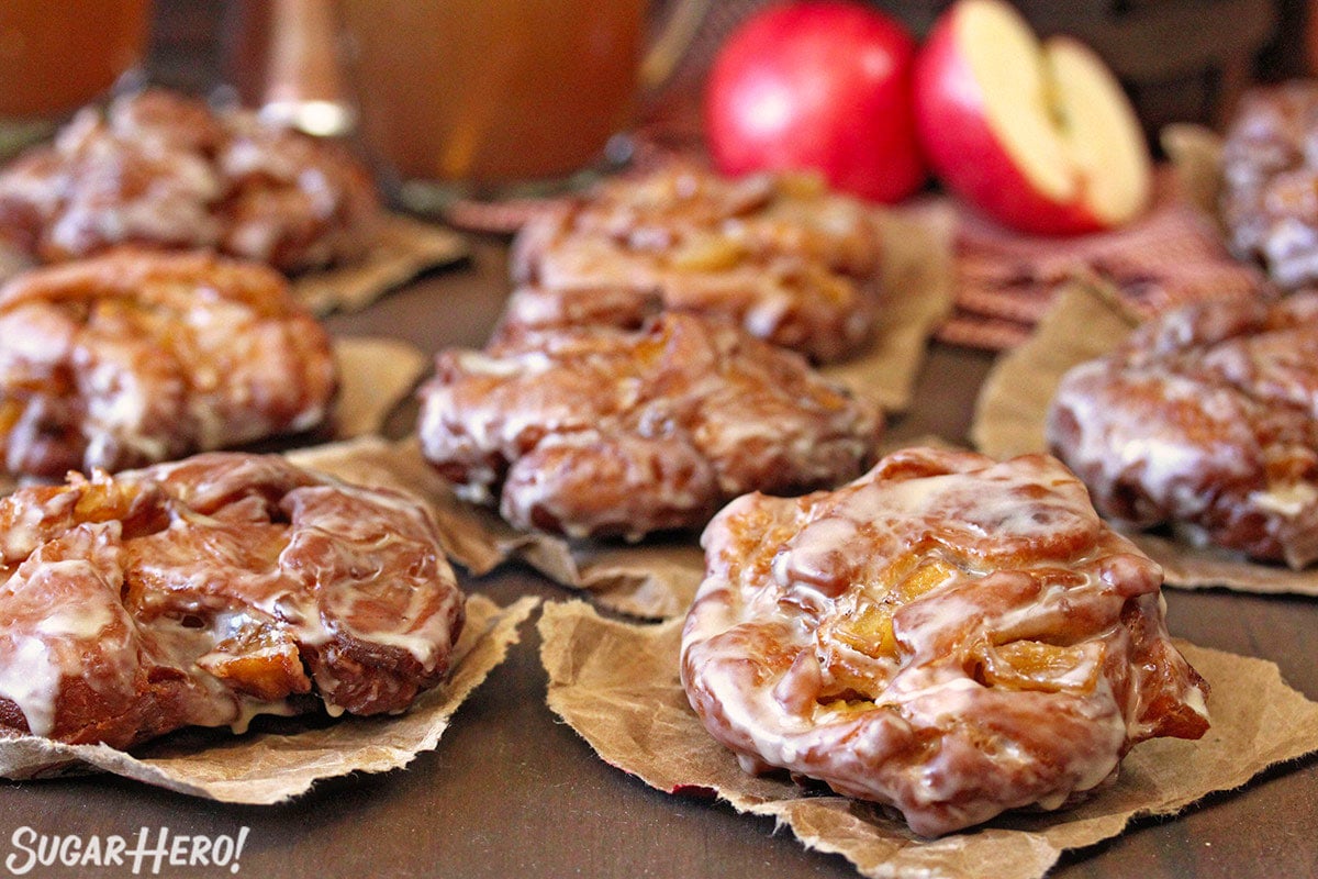 3 Apple Cider Fritters cooling on brown paper.