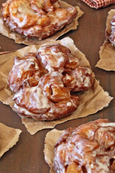 Apple Cider Fritters cooling on brown paper.