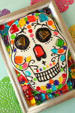 Chocolate Skull Cake on a silver platter surrounded by candy jewels.