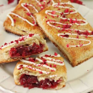 3 Cranberry White Chocolate Sweetie Pies on a plate with the front pie cut in half to show inside.