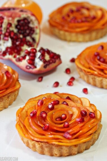 Close up of a Persimmon Almond Rosette Tart sprinkled with pomegranate arils.