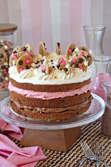Neapolitan Chocolate Chip Cookie Cake on a cake platter with colorful chocolate milk in the background.