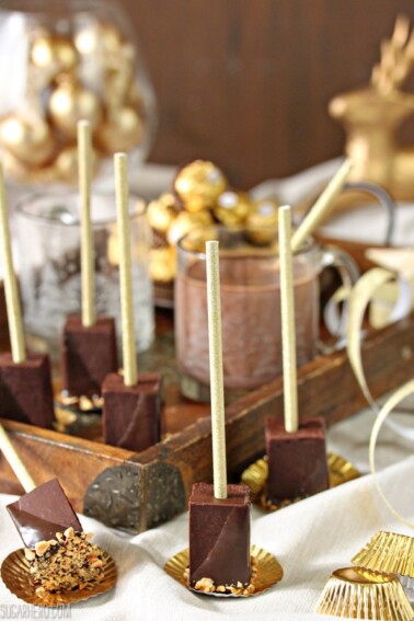 Several pieces of Hazelnut Hot Chocolate On A Stick with a wooden serving tray in the background.