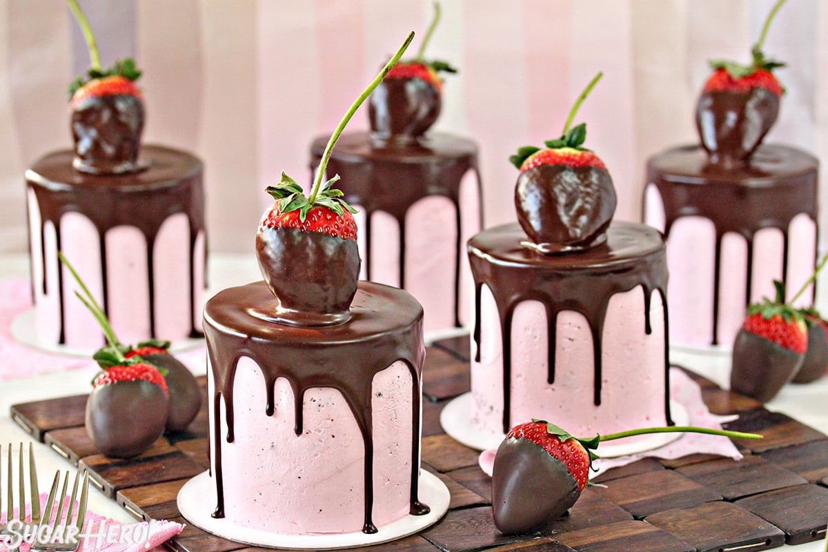 Chocolate-Covered Strawberry Cakes - Five separate cakes with strawberry's top of each and some displayed on the sides. | From SugarHero.com