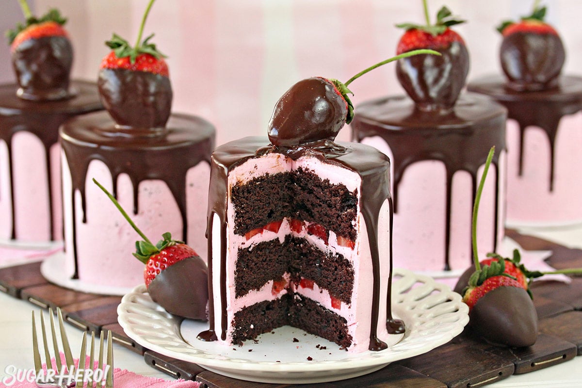 Five Chocolate-Covered Strawberry Cakes, with the front one cut open to show the cake and buttercream layers inside.