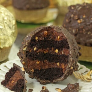 Close up of a Giant Ferrero Rocher Hazelnut Mousse Cake with portion cut away to show inside layers.