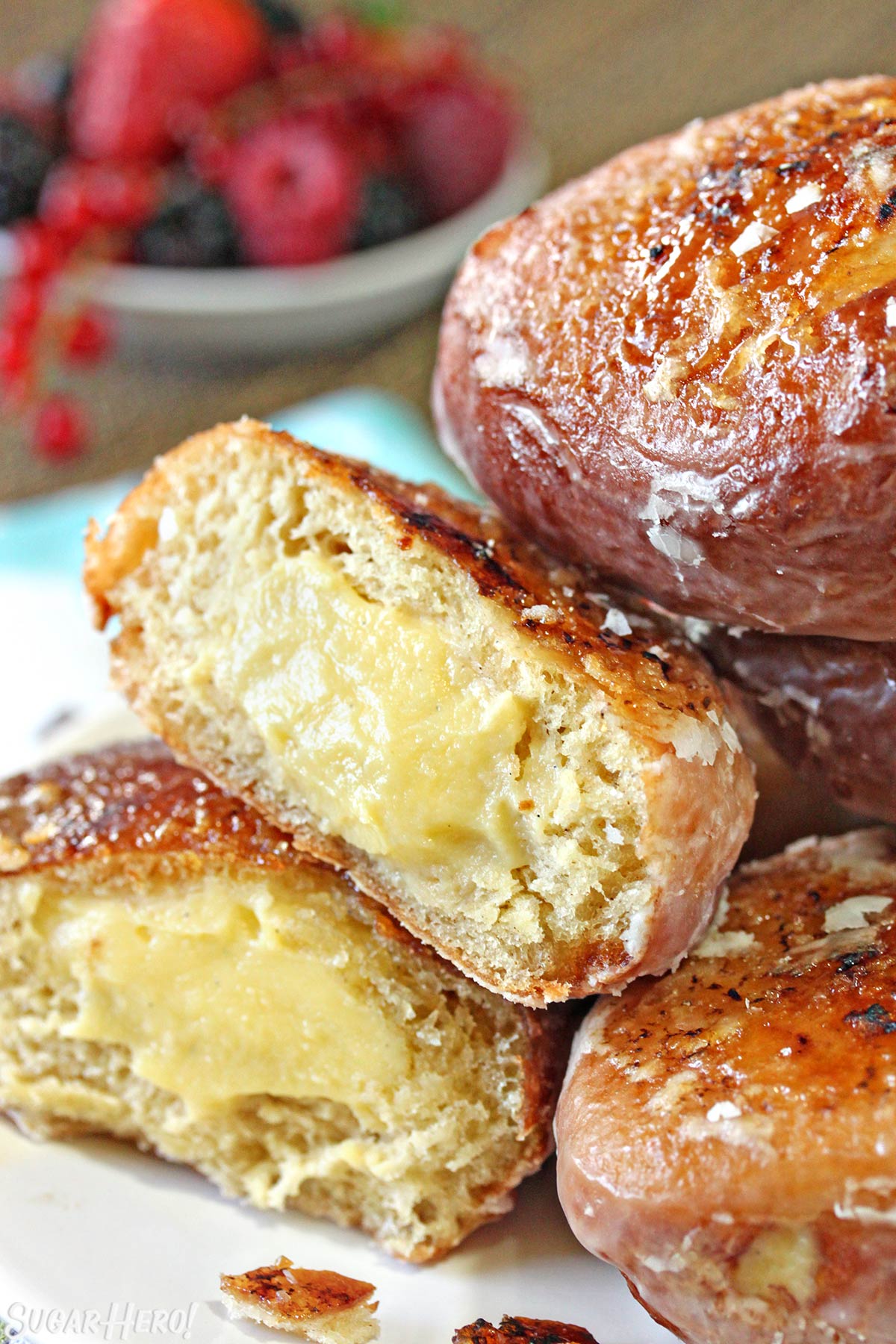 A Crème Brûlée Donut cut in half to show the vanilla pastry cream filling in the center.