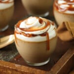 Close view of several Butterscotch Pots de Creme on a wooden serving tray.