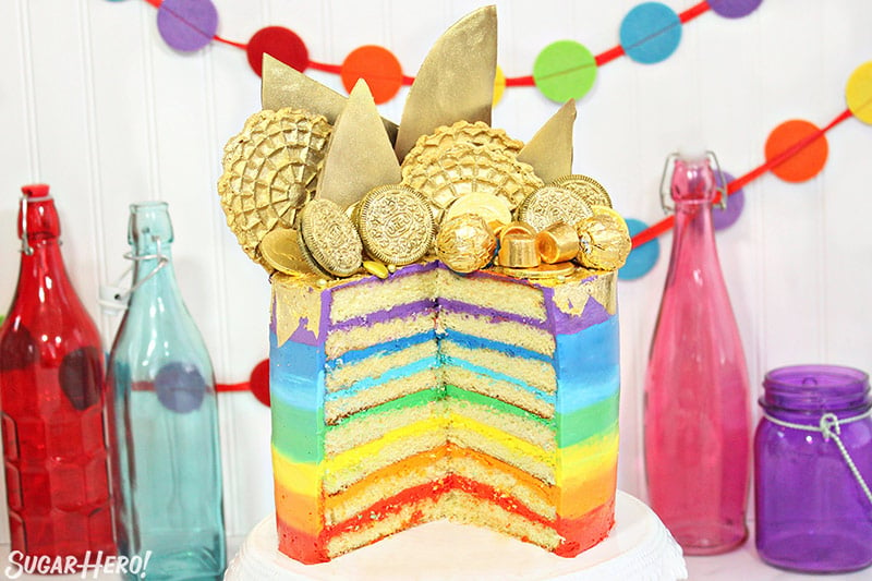Gold-Topped Rainbow Cake sliced open, revealing the multi-colored rainbow frosting layers inside.