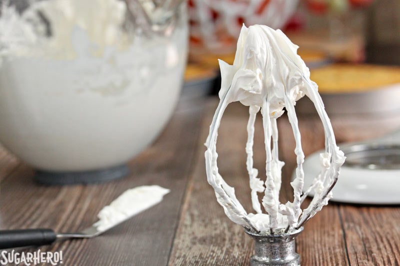 How to Make Swiss Meringue Buttercream - A close up of the whisk with the buttercream on it.  | From SugarHero.com