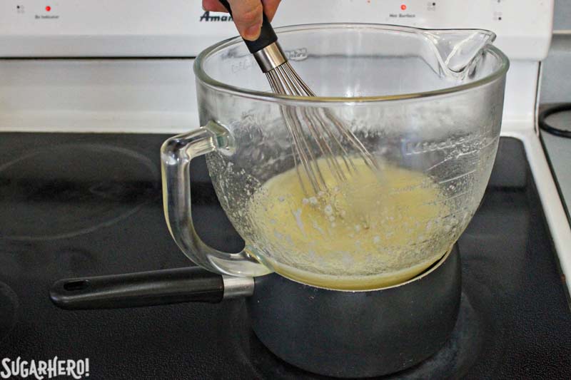 How to Make Swiss Meringue Buttercream - A picture of the bowl and sugar being heated and stirred.  | From SugarHero.com