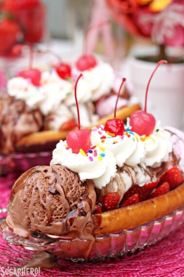 Close up of a Doughnut Ice Cream Sundae with whipped cream and cherries on top.