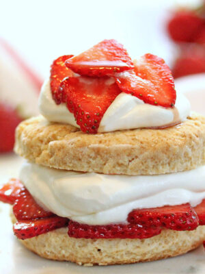 Strawberry shortcake topped with whipped cream and sliced strawberries.
